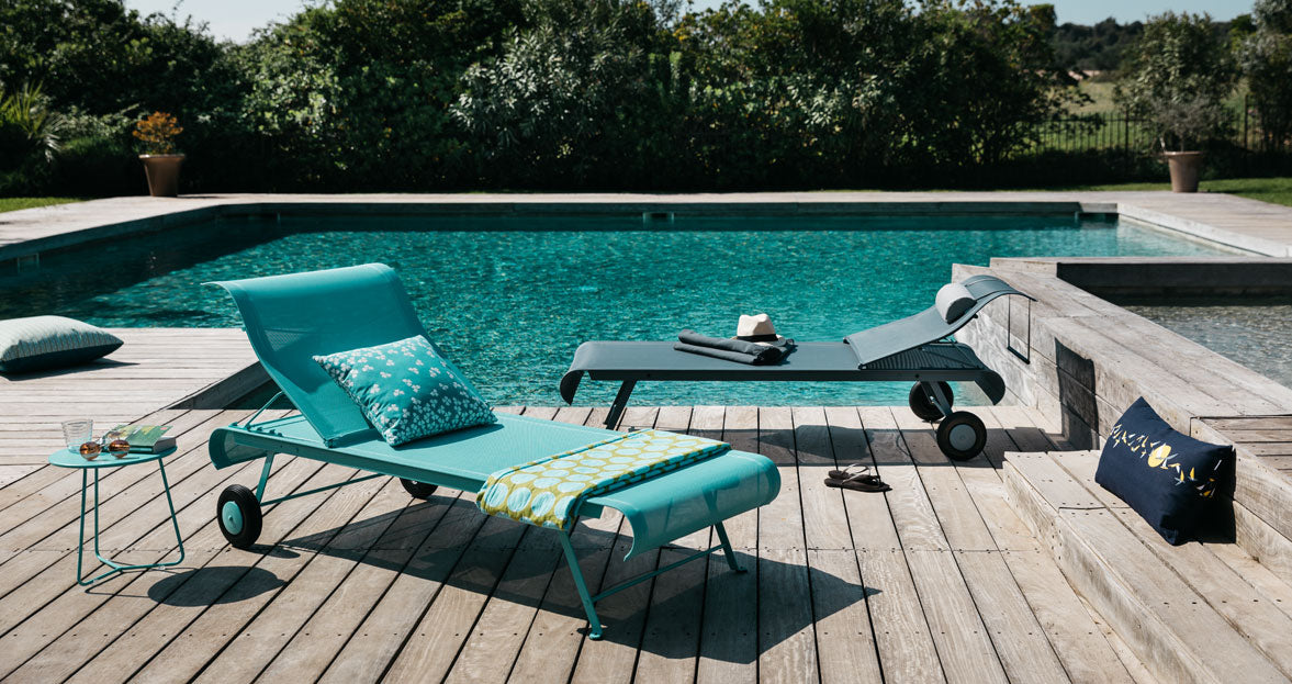 Cocotte Small Side Table by Fermob, showing front view of small side table with sunlounger in the live shot.