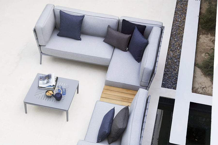 Conic Outdoor Module by Cane-Line, showing conic outdoor modules with table in live shot.