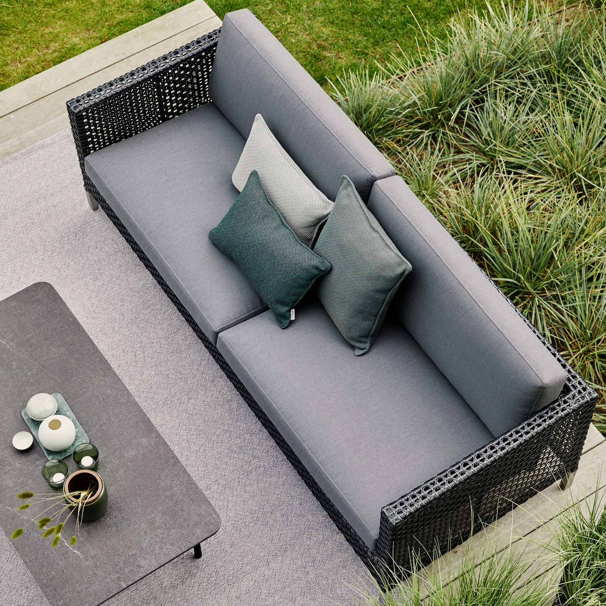 Connect 3 Seater Sofa by Cane-Line, showing connect 3 seater sofa with table in live shot.