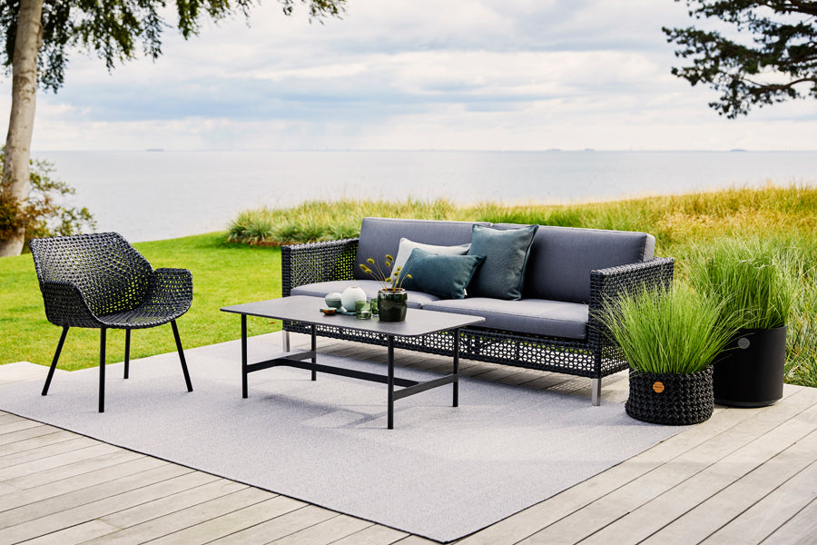 Connect 3 Seater Sofa by Cane-Line, showing connect 3 seater sofa with table & chair in live shot.