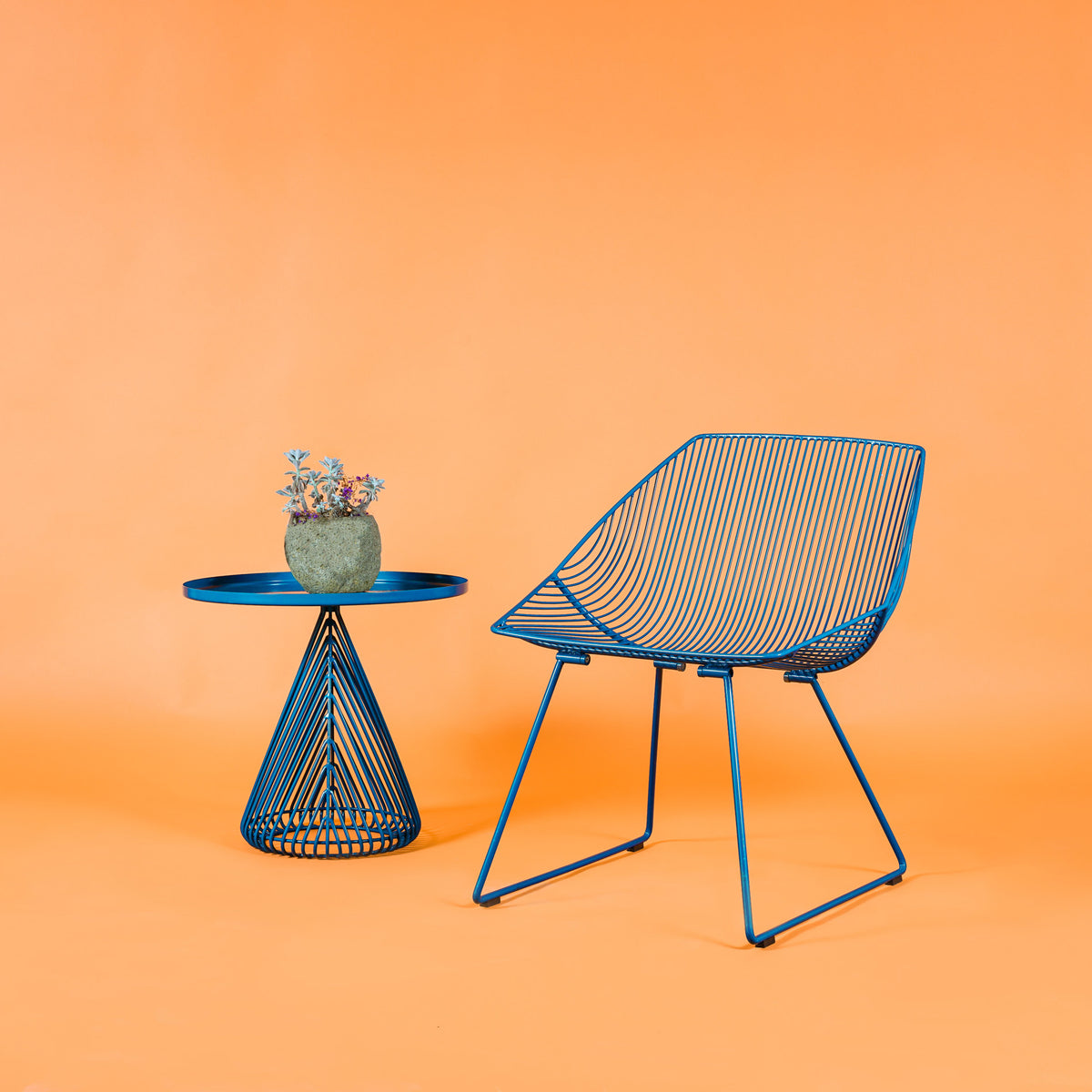 Cono Side Table by Bend, showing cono side table with chair in live shot.