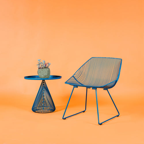 Cono Side Table by Bend, showing cono side table with chair in live shot.