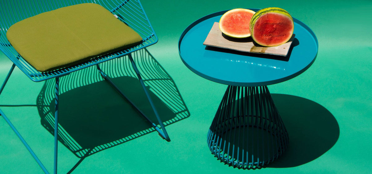 Cono Side Table by Bend, showing cono side table with chair in live shot.