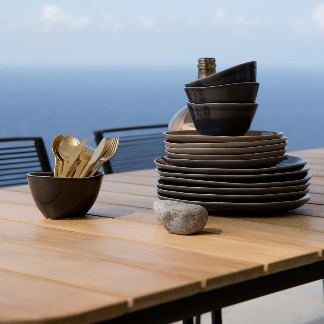 Core Dining Table by Cane-Line, showing closeup view of core dining table with chairs in live shot.