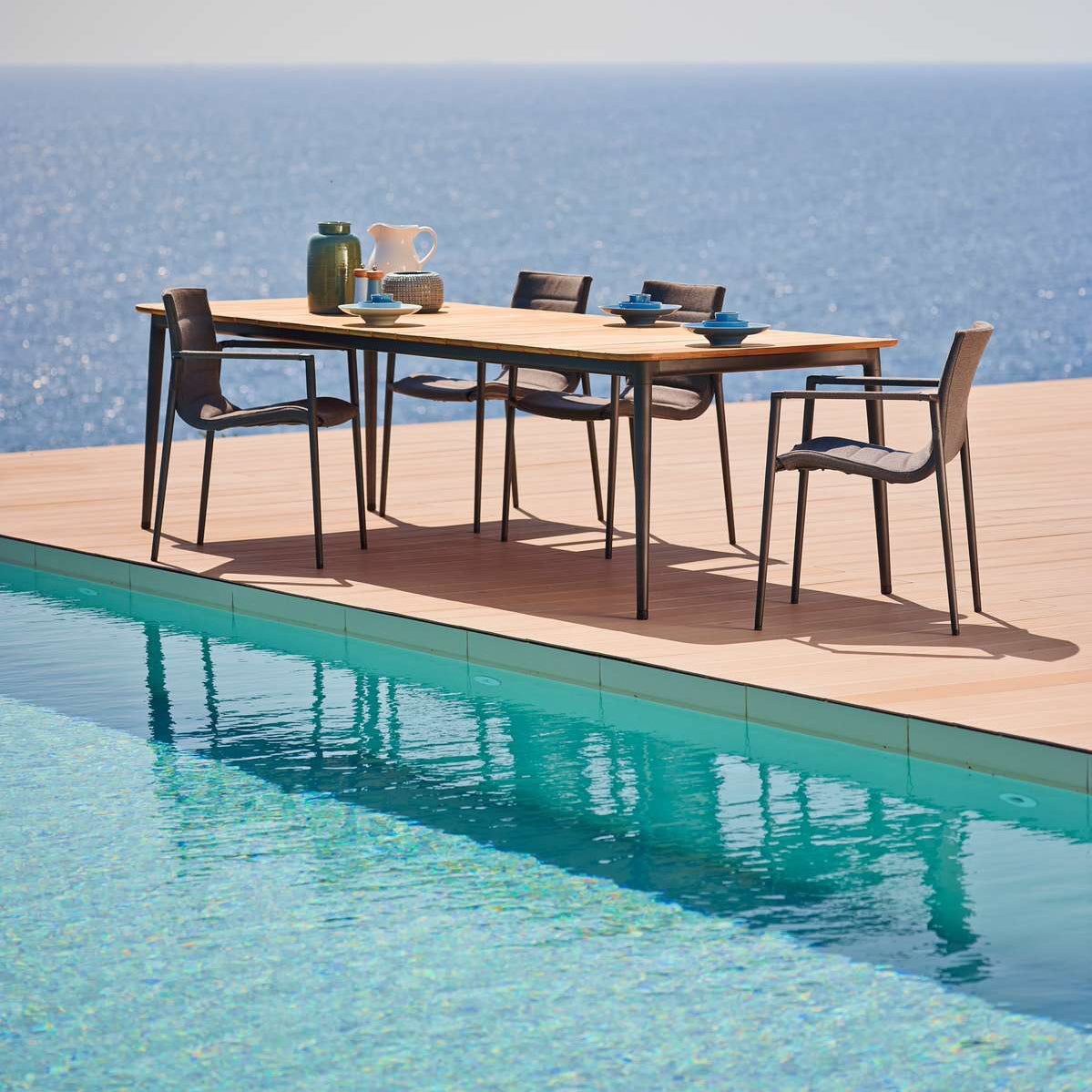 Core Dining Table by Cane-Line, showing core dining table with chairs in live shot.