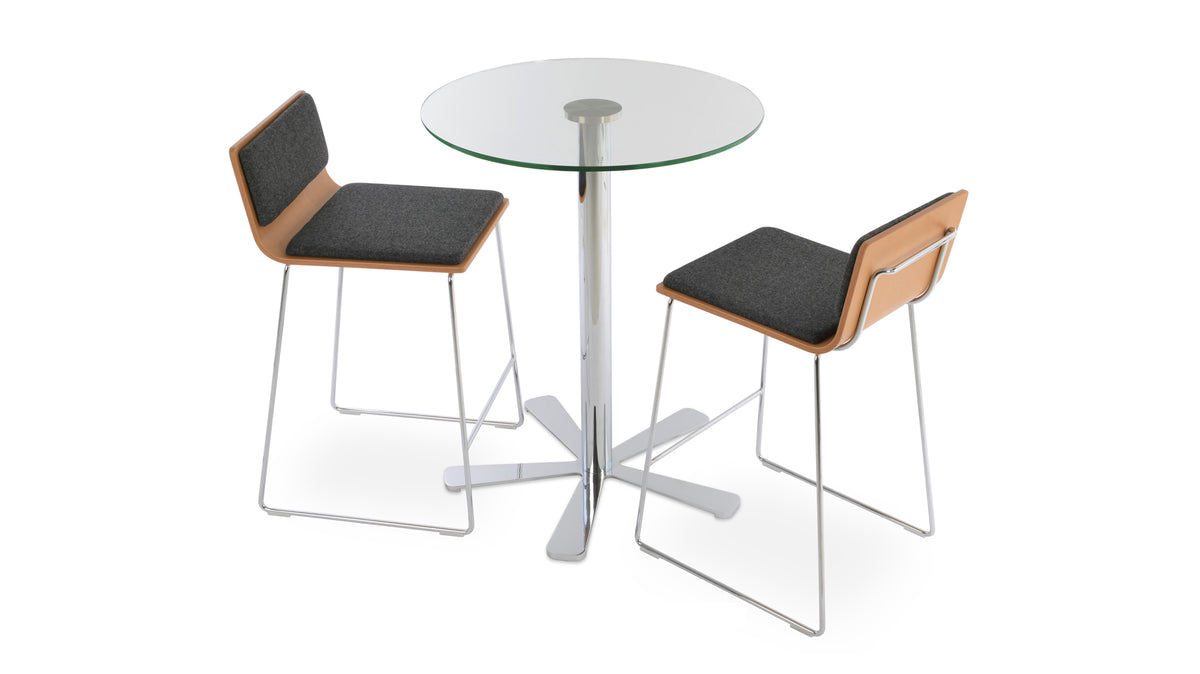 Corona Handle Back Wire Counter Stool by SohoConcept, showing angle view of two stools in camira blazer dark grey wool seat pad, natural plywood seat with chrome wire base & daisy glass bar table.