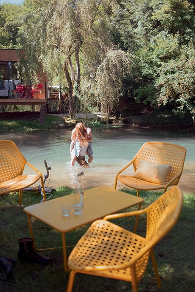 Croisette Armchair by Fermob, showing armchairs with table in live shot.