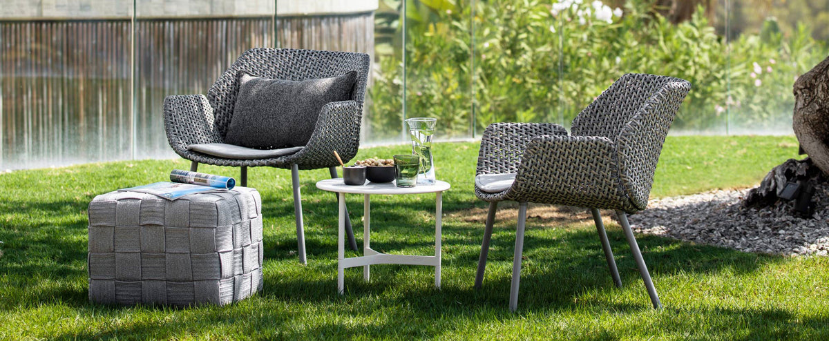 Cube Footstool by Cane-Line, showing cube footstool in live shot.