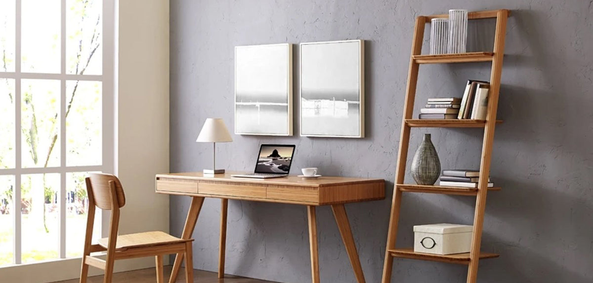 Currant Leaning Bookshelf by Greenington, showing angle view of leaning bookshelf with writing desk and chair in live shot.