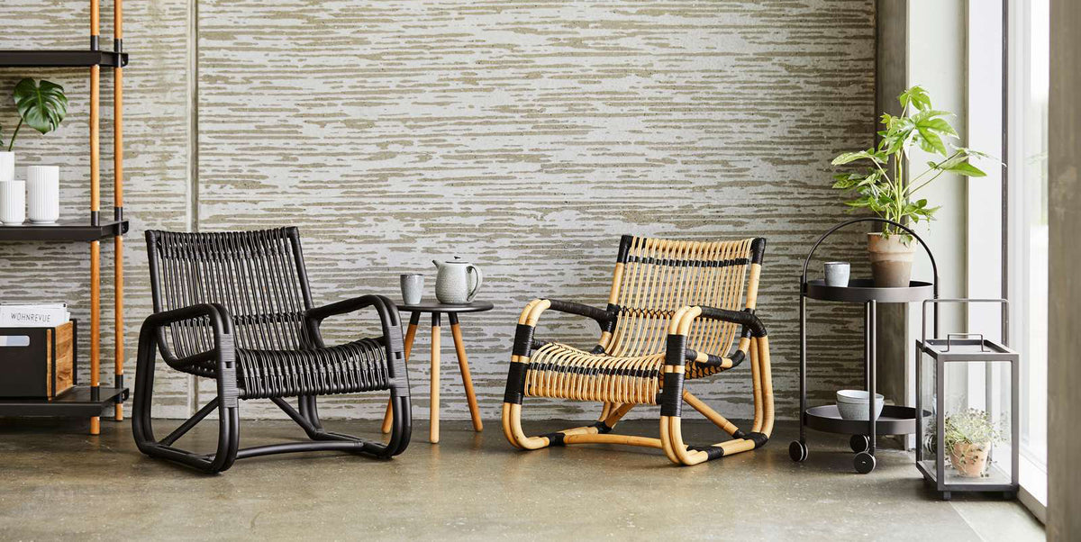 Curve Indoor Lounge Chair by Cane-Line, showing curve indoor lounge chairs with table in live shot.