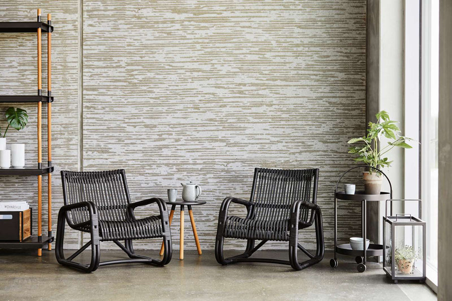 Curve Indoor Lounge Chair by Cane-Line, showing curve indoor lounge chairs with table in live shot.