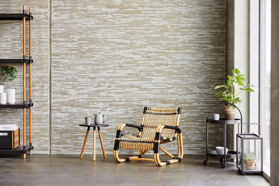 Curve Indoor Lounge Chair by Cane-Line, showing curve indoor lounge chair with table in live shot.