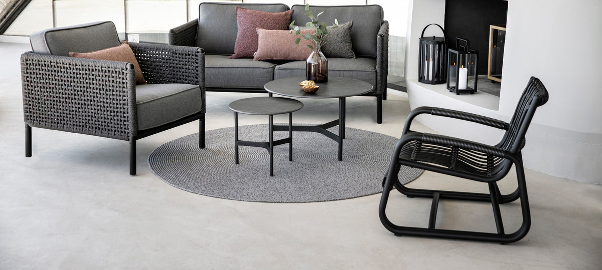 Curve Outdoor Lounge Chair by Cane-line, showing curve outdoor lounge chair with tables, sofa & chair in live shot.