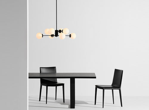 Dylan Pendant by Nuevo, showing front view of white glass shade with matte black body pendant in live shot.