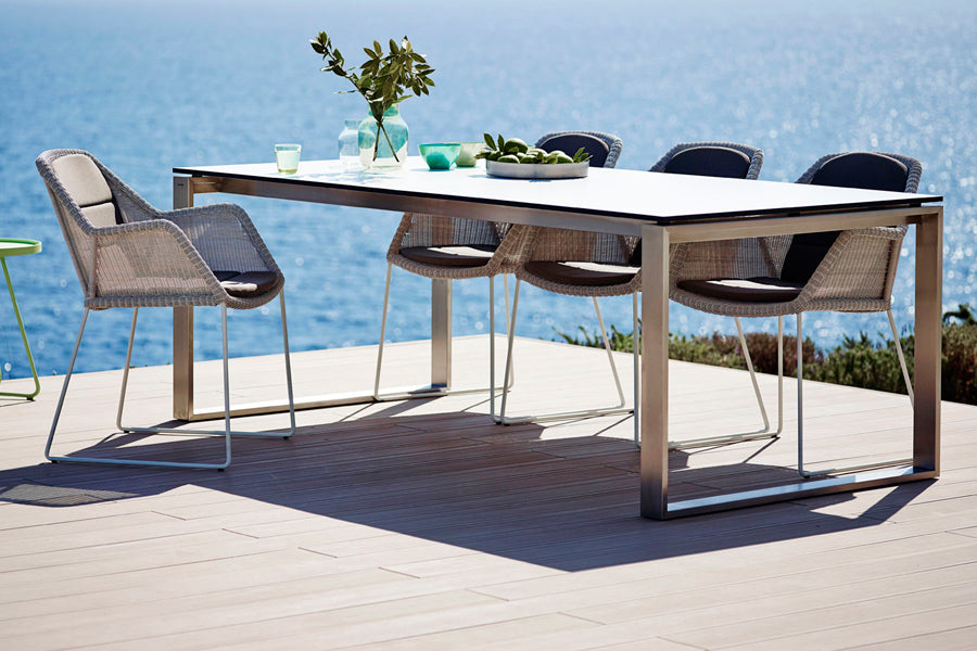 Edge Dining Table with Extension Leaves by Cane-Line, showing edge dining table in live shot.