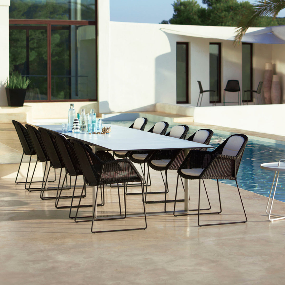 Edge Dining Table with Extension Leaves by Cane-Line, showing edge dining table with extension leaves in live shot.