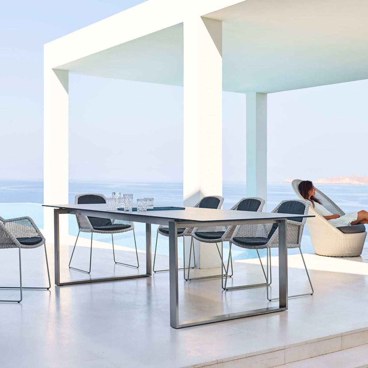 Edge Dining Table with Extension Leaves by Cane-Line, showing edge dining table with extension leaves in live shot.