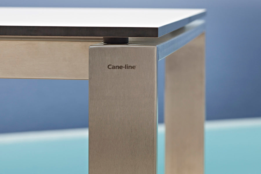 Edge Dining Table with Extension Leaves by Cane-Line, showing closeup view of edge dining table in live shot.