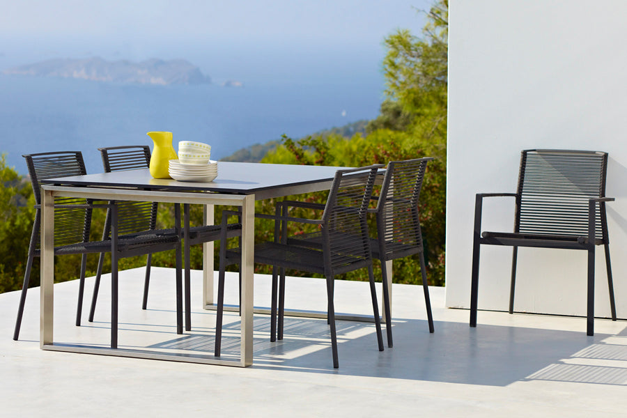 Edge Dining Table with Extension Leaves by Cane-Line, showing edge dining table in live shot.