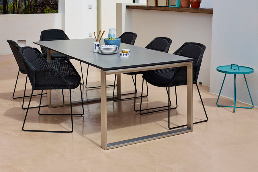 Edge Dining Table with Extension Leaves by Cane-Line, showing edge dining table in live shot.
