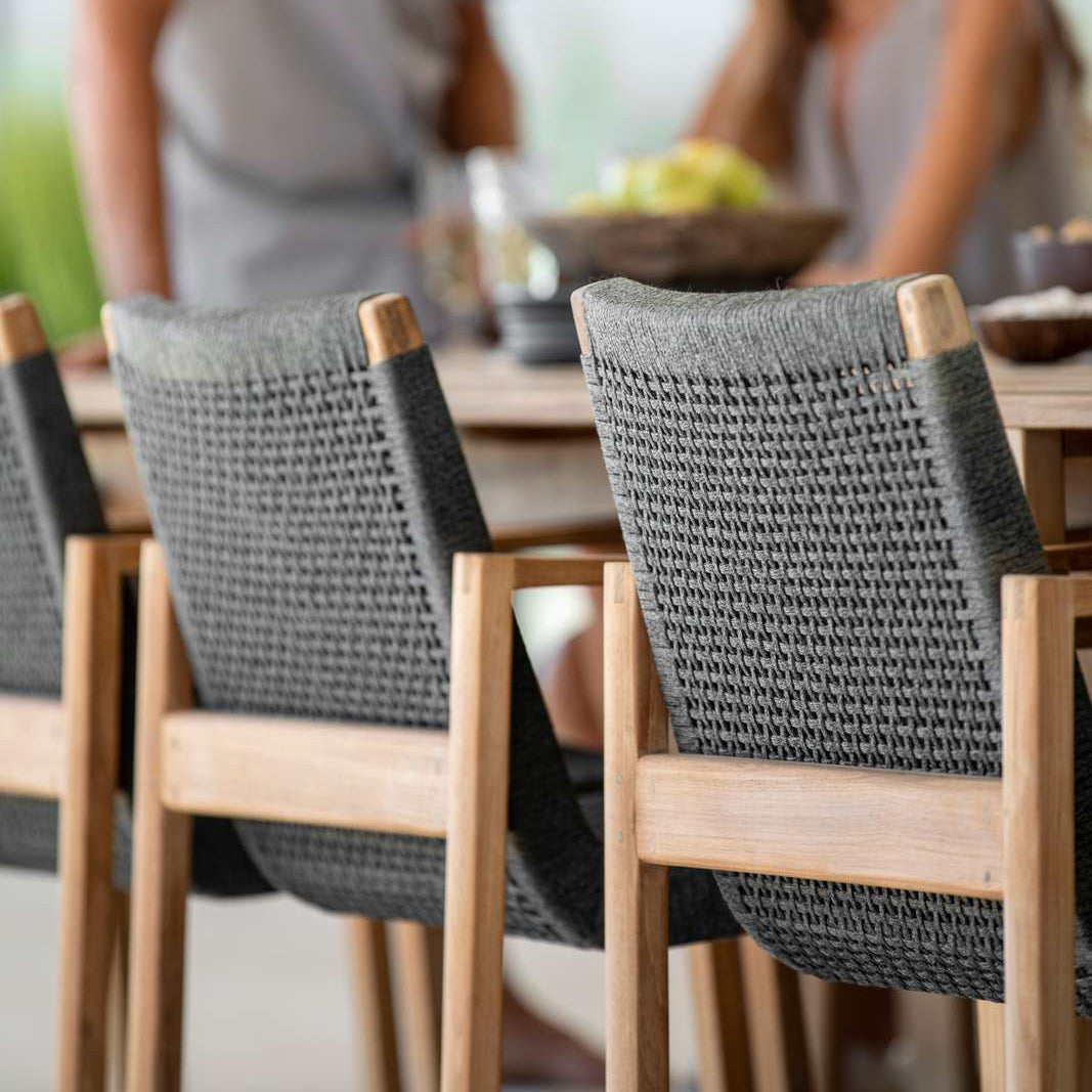 Endless Outdoor Dining Chair by Cane-Line, showing endless outdoor dining chairs with table in live shot.