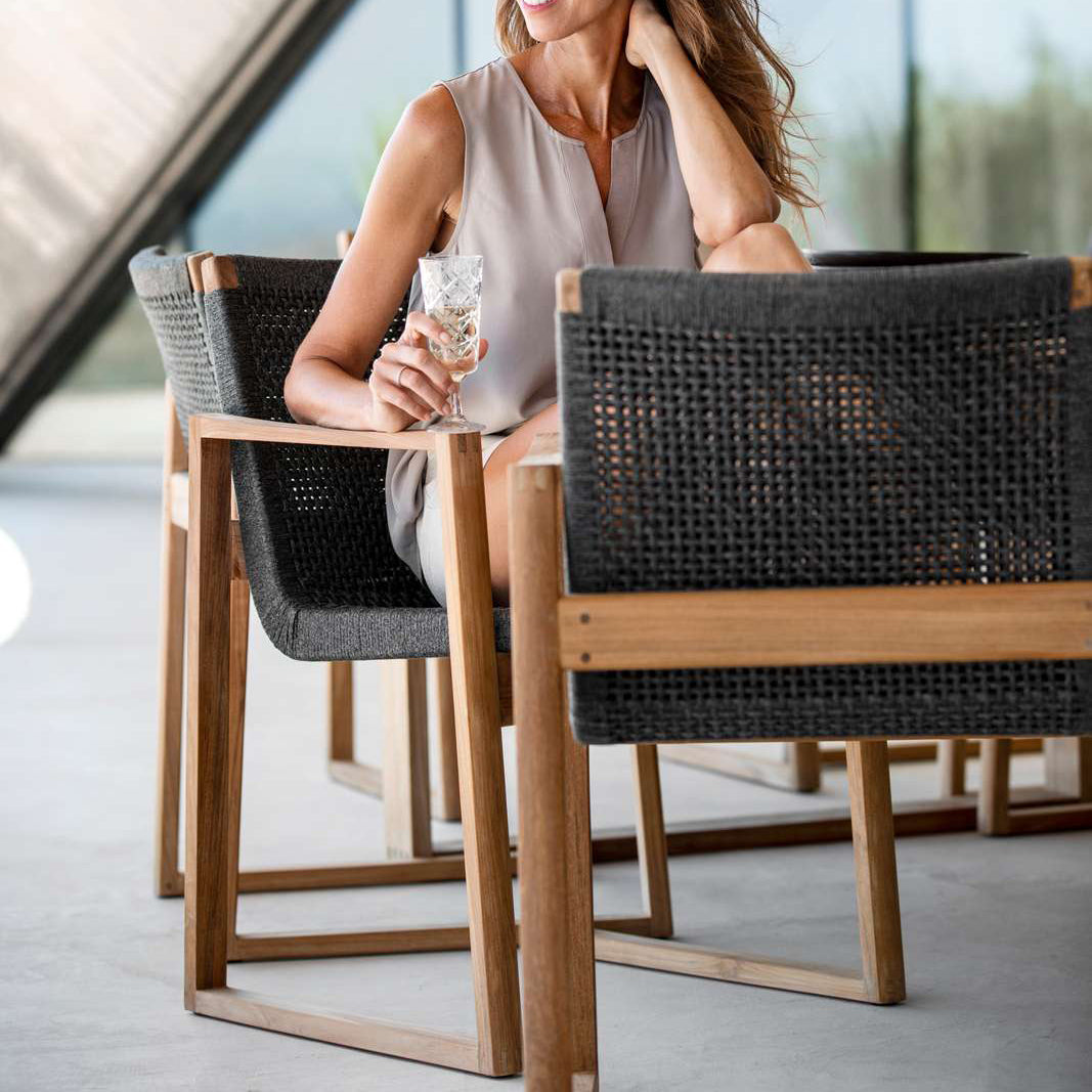 Endless Outdoor Dining Chair by Cane-Line, showing endless outdoor dining chairs with table in live shot.