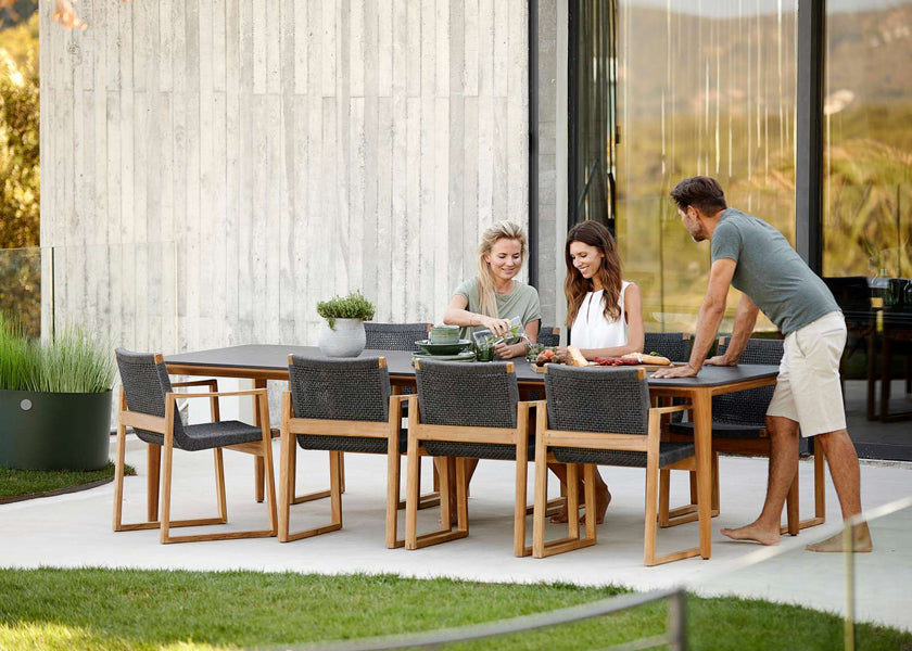 Endless Outdoor Dining Chair by Cane-Line, showing endless outdoor dining chairs with table in live shot.