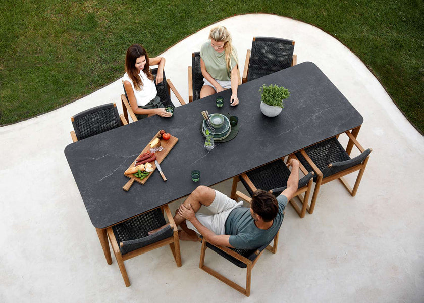 Endless Outdoor Dining Chair by Cane-Line, showing endless outdoor dining chairs with table in live shot.