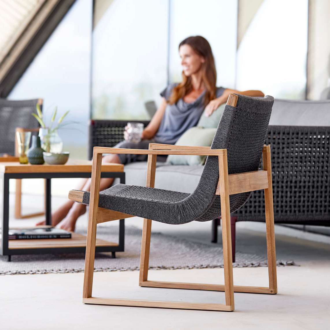 Endless Outdoor Lounge Chair by Cane-Line, showing endless outdoor lounge chair with table & sofa in live shot.