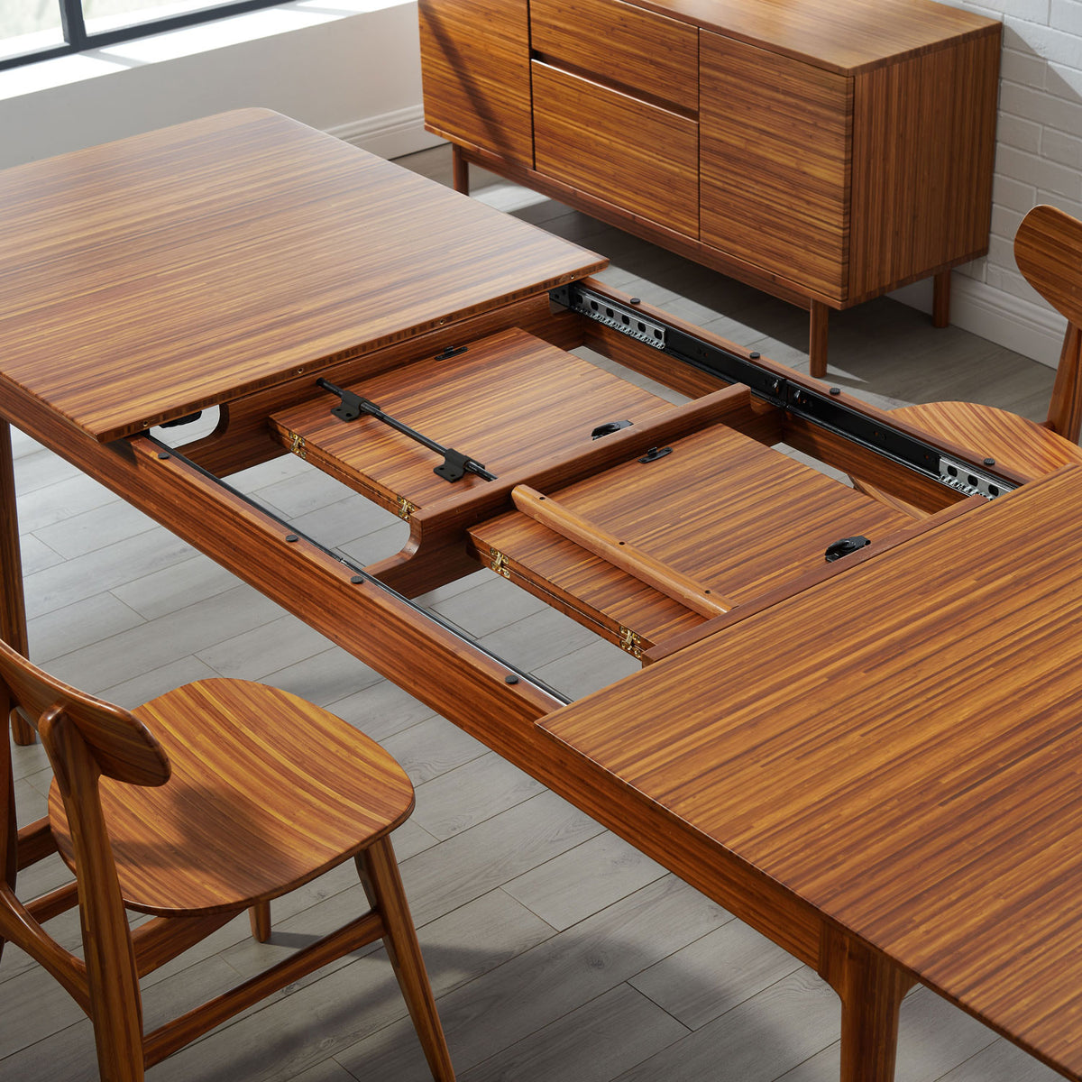 Erikka Double Leaves Extendable Dining Table by Greenington, showing closeup view of erikka double leaves extendable dining table with chairs in live shot.