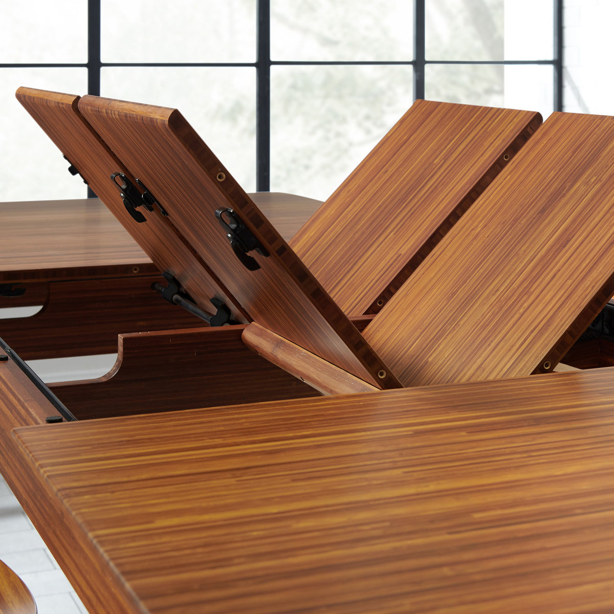 Erikka Double Leaves Extendable Dining Table by Greenington, showing closeup view of erikka double leaves extendable dining table with chairs in live shot.