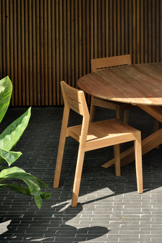EX 1 Teak Outdoor Dining Chair by Ethnicraft, showing closeup view of teak outdoor dining chair with table in live shot.