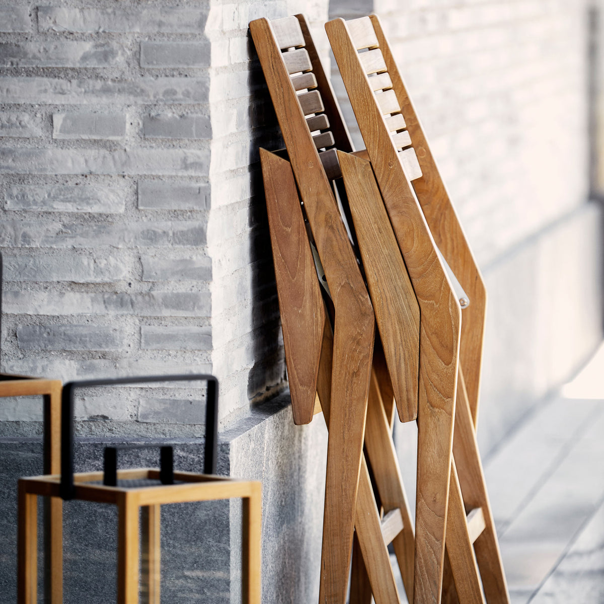 Flip Folding Teak Dining Armchair by Cane-Line, showing flip folding teak dining armchairs in live shot.
