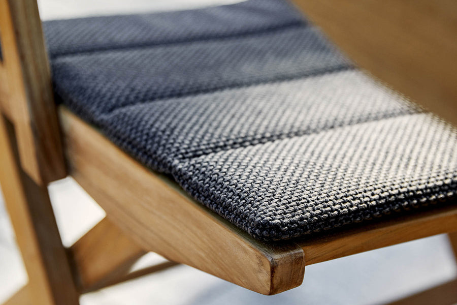 Flip Folding Teak Dining Armchair by Cane-Line, showing closeup view of flip folding teak dining armchair in live shot.