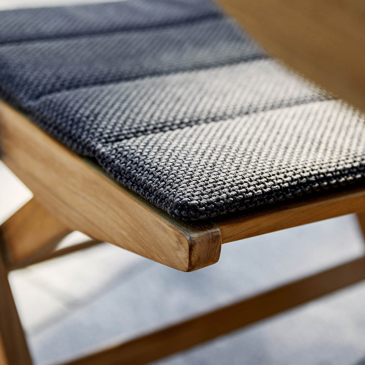 Flip Folding Teak Dining Chair by Cane-Line, showing closeup view of flip folding teak dining chair in live shot.