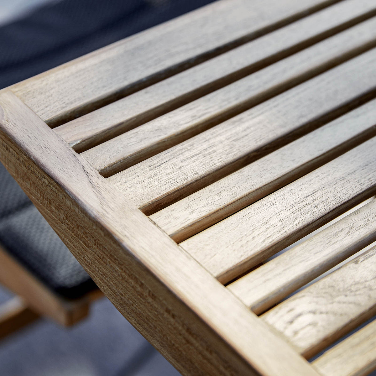 Flip Folding Teak Dining Table by Cane-Line, showing closeup view of flip folding teak dining table in live shot.
