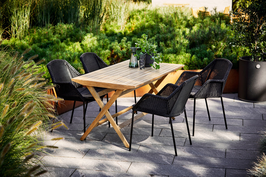 Flip Folding Teak Dining Table by Cane-Line, showing flip folding teak dining table with dining chairs in live shot.