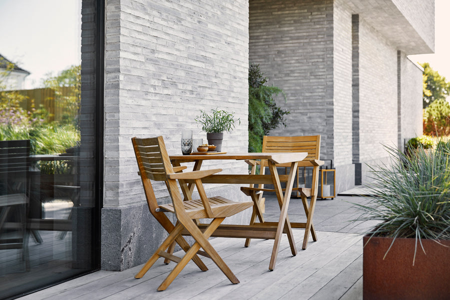 Flip Folding Teak Dining Table by Cane-Line, showing flip folding teak dining table with dining chairs in live shot.
