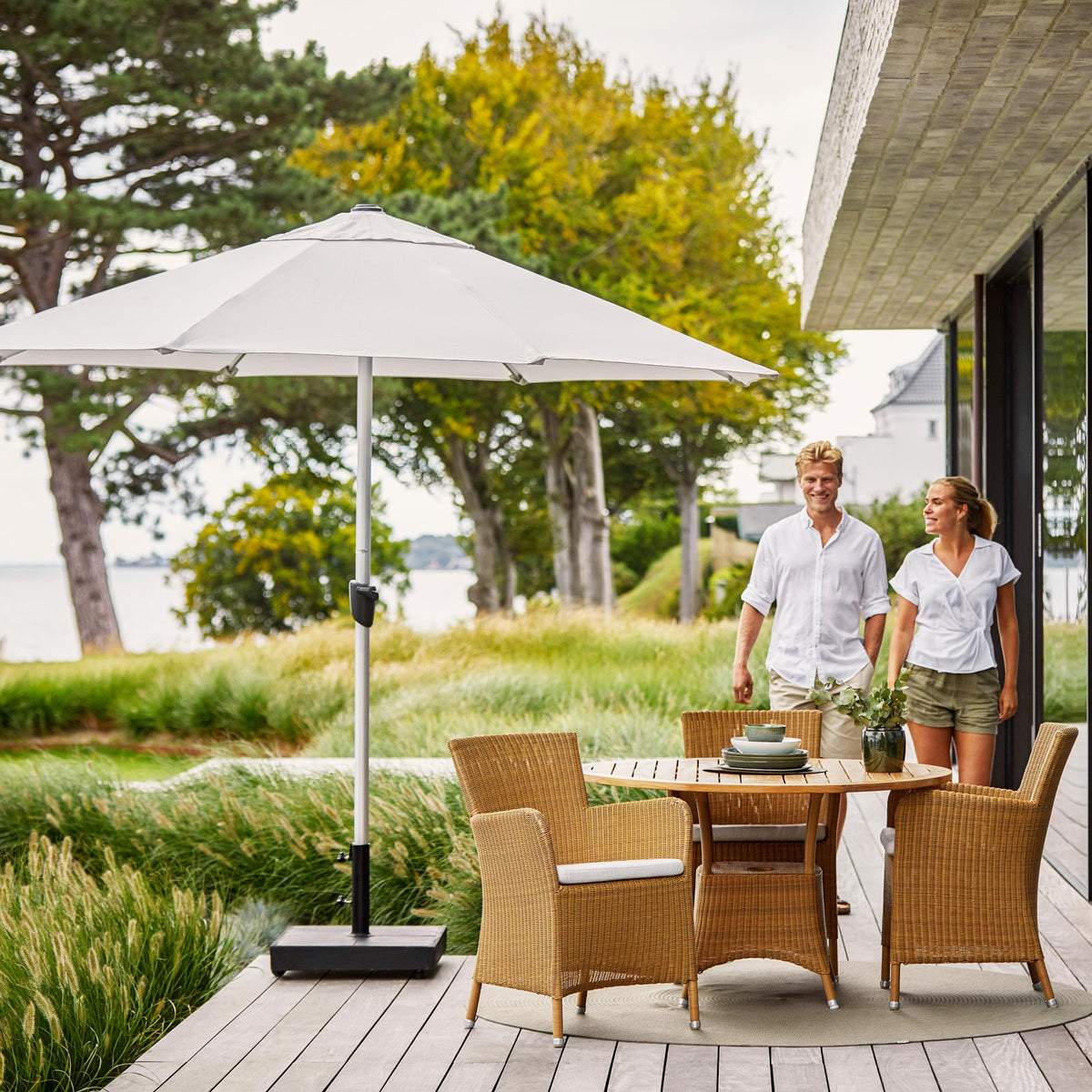 Hampsted Outdoor Dining Chair by Cane-Line, showing hampsted outdoor dining chairs with table in live shot.