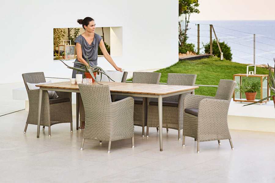Hampsted Outdoor Dining Chair by Cane-Line, showing hampsted outdoor dining chairs with table in live shot.