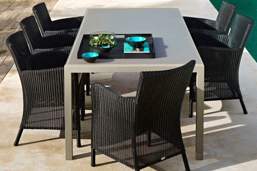 Hampsted Outdoor Dining Chair by Cane-Line, showing hampsted outdoor dining chairs with table in live shot.