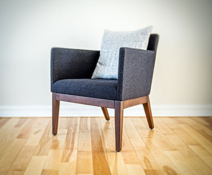 Harput Wood Lounge Chair by SohoConcept, showing angle view of small lounge chairs with pillow in live shot.