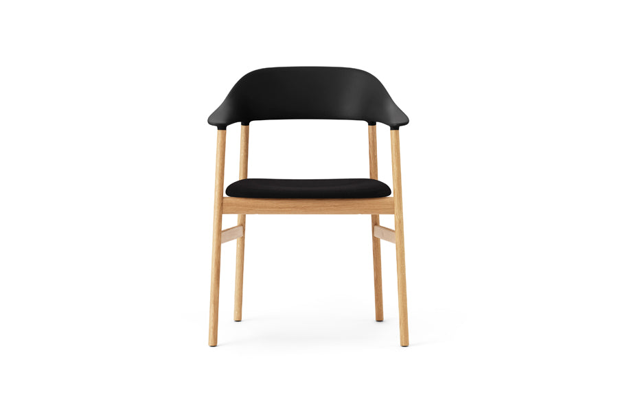 Herit Upholstery Armchair by Normann Copenhagen, showing front view of herit upholstery armchair in oak wood legs/black synergy fabric seat.