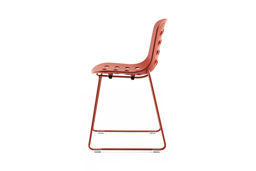 Holi Sled Base Side Chair by Toou, showing side view of holi sled base side chair in open shell/red terracotta.
