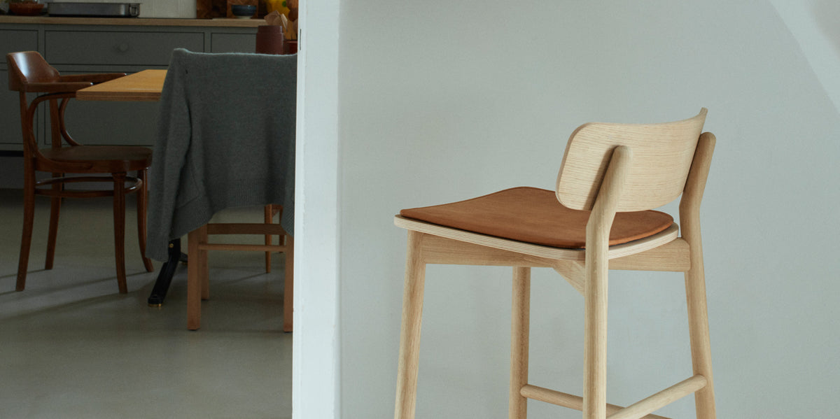 Hven Oak Low Bar Stool by Skagerak, showing back view of hven oak low bar stool in live shot.