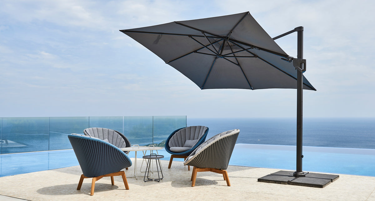 Hyde Luxe Parasol by Cane-Line, showing hyde luxe parasol with chairs & tables in live shot.