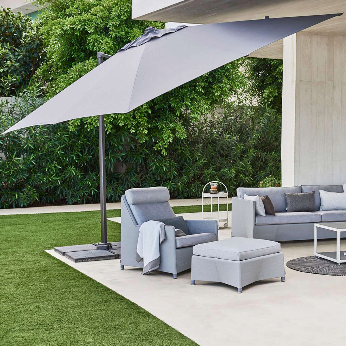 Hyde Luxe Parasol by Cane-Line, showing hyde luxe parasol with sofa, chairs & tables in live shot.