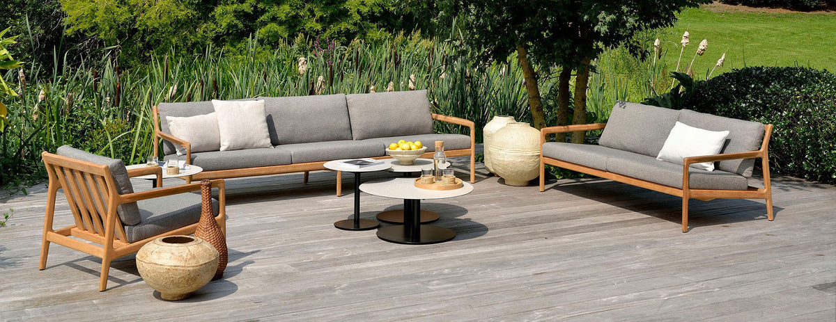 Jack Outdoor Sofa by Ethnicraft, showing jack outdoor sofas with chair & tables in live shot.