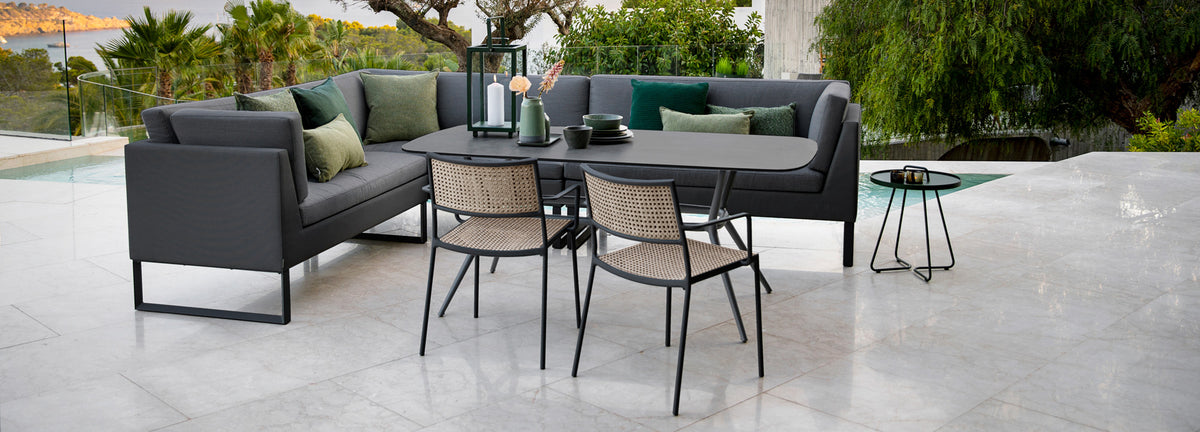 Joy Outdoor Oval Dining Table by Cane-Line, showing joy outdoor oval dining table in live shot.