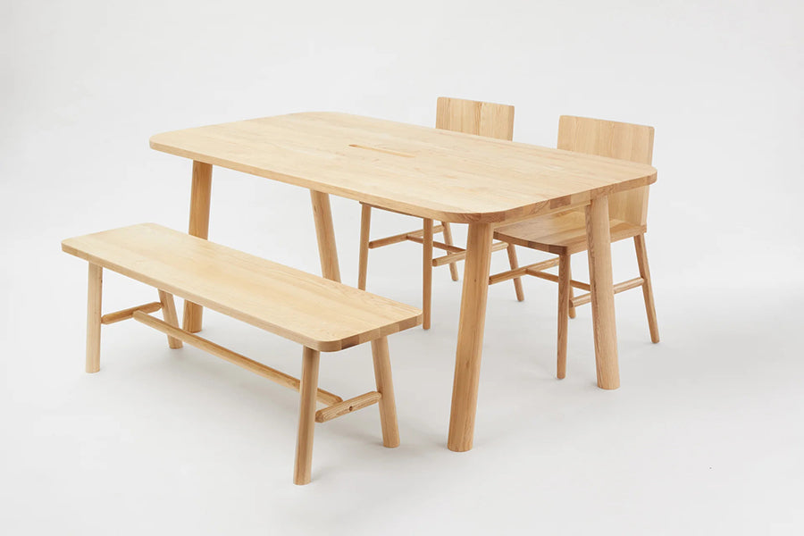 LAX Milk Dining Table by MASHstudios, showing angle view of lax milk dining table with bench & chairs in solid ash wood.